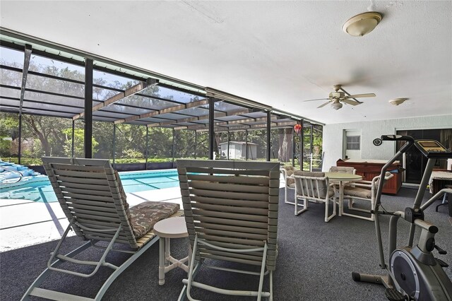 swimming pool with a covered hot tub, a ceiling fan, a patio, and a lanai