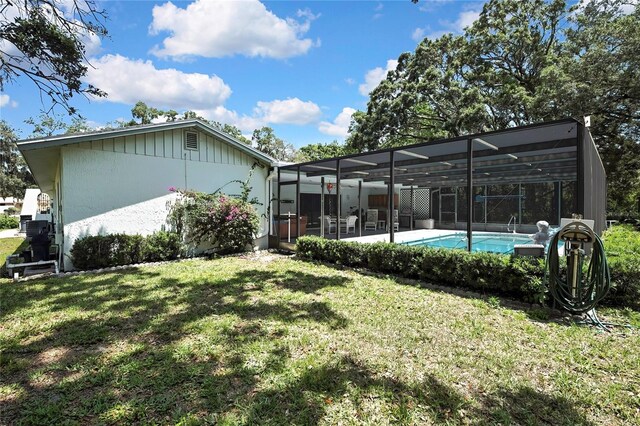 back of house with a lawn, a lanai, a patio, and an outdoor pool