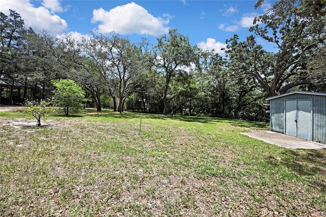 view of grassy yard featuring a shed and an outbuilding