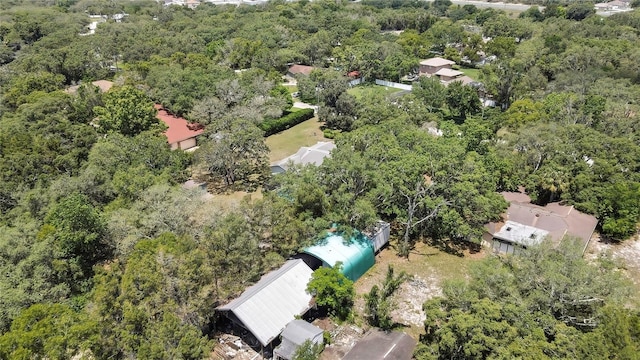 aerial view of property and surrounding area with a heavily wooded area