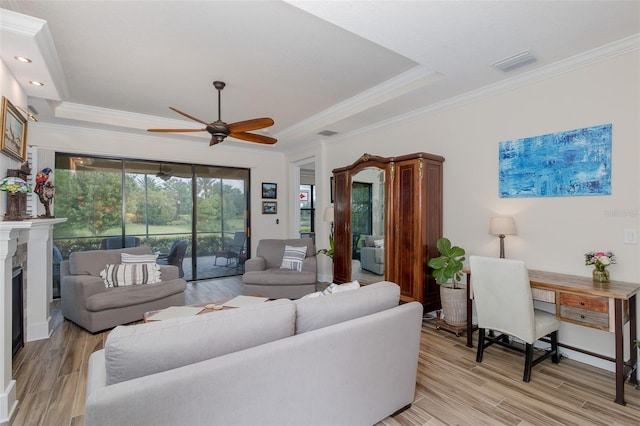 11611 Callisia Dr, Odessa, FL 33556 - living area with ceiling fan, ornamental molding, a raised ceiling, light wood-type flooring, and a fireplace