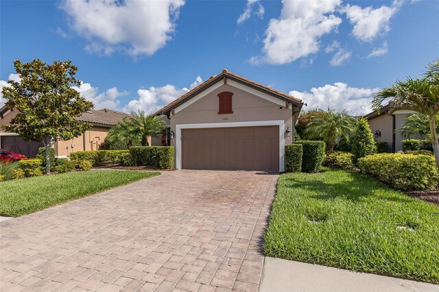 11611 Callisia Dr, Odessa, FL 33556 - ranch-style house with decorative driveway, a front lawn, stucco siding, and an attached garage