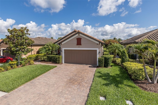 11611 Callisia Dr, Odessa, FL 33556 - view of front of house featuring decorative driveway, stucco siding, a front lawn, an attached garage, and a tile roof