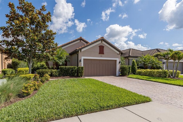 11611 Callisia Dr, Odessa, FL 33556 - view of front facade featuring a garage, decorative driveway, a front lawn, stucco siding, and a tile roof