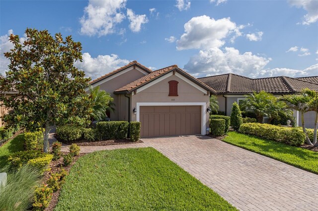 11611 Callisia Dr, Odessa, FL 33556 - mediterranean / spanish-style home featuring decorative driveway, an attached garage, stucco siding, and a front lawn