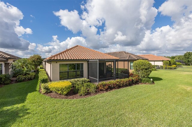 11611 Callisia Dr, Odessa, FL 33556 - rear view of house featuring a tiled roof, a yard, a sunroom, and stucco siding