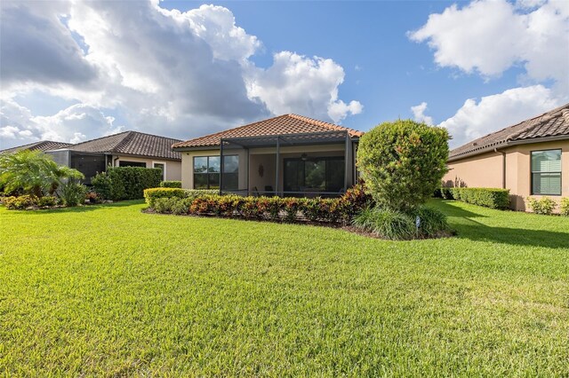 11611 Callisia Dr, Odessa, FL 33556 - back of property with a tiled roof, a lawn, stucco siding, and ceiling fan
