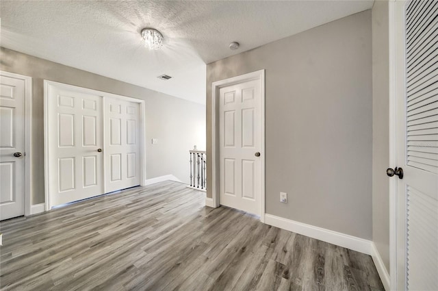 6222 Cherry Blossom Trl, Gibsonton, FL 33534 - unfurnished bedroom featuring wood finished floors, baseboards, a closet, and a textured ceiling