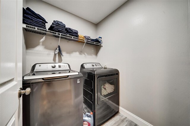 6222 Cherry Blossom Trl, Gibsonton, FL 33534 - laundry area featuring washing machine and clothes dryer, light wood-style flooring, and baseboards