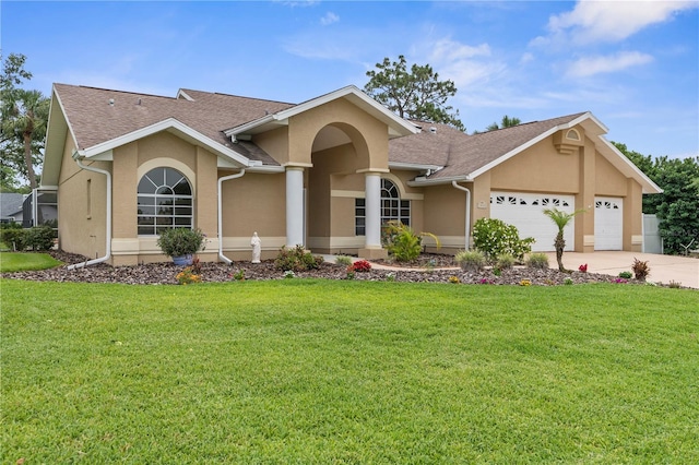 view of front facade featuring stucco siding, a garage, a front lawn, and driveway