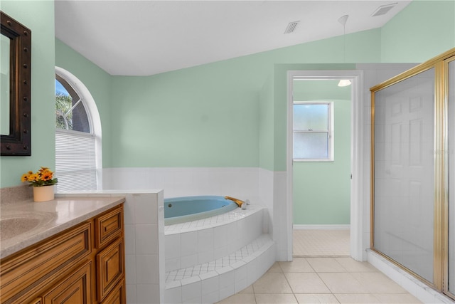 bathroom featuring vaulted ceiling, a shower stall, a bath, tile patterned flooring, and vanity