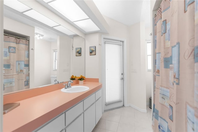 full bathroom featuring toilet, vanity, tile patterned flooring, and baseboards