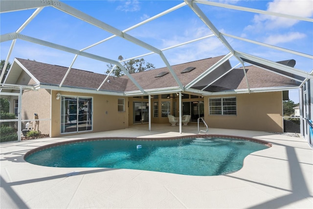 outdoor pool with a patio area, glass enclosure, and ceiling fan