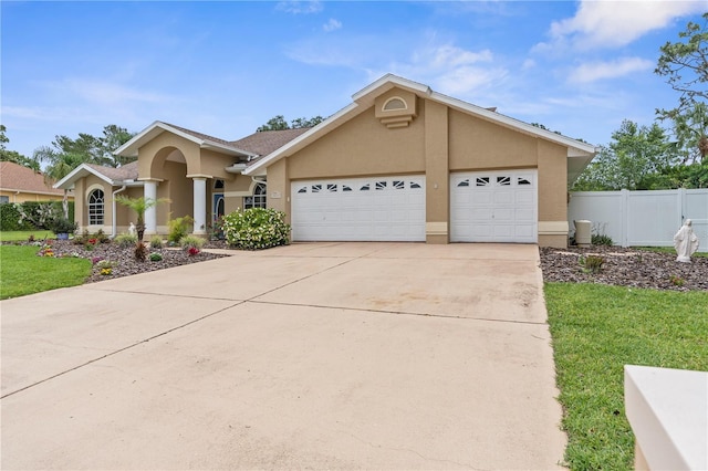 view of front of property with stucco siding, an attached garage, and driveway