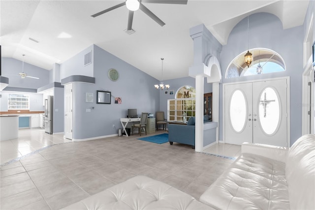 entryway with a ceiling fan, high vaulted ceiling, a chandelier, and light tile patterned floors
