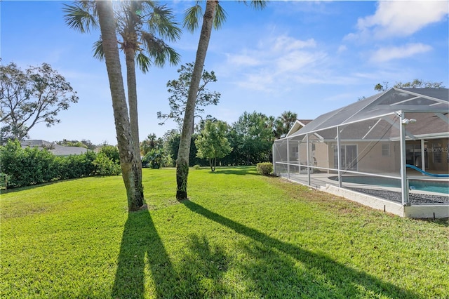 view of green lawn featuring an outdoor pool and glass enclosure