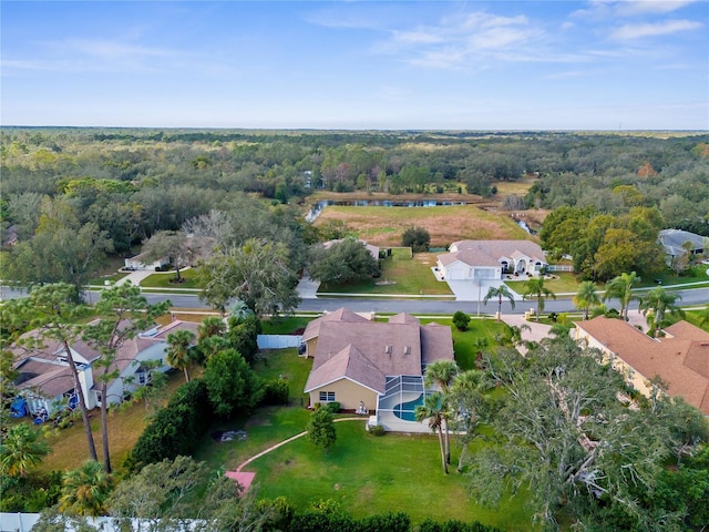 view of property location featuring nearby suburban area and a forest