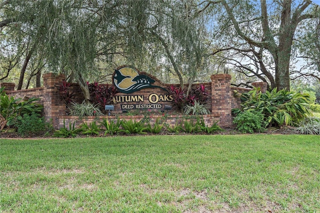 community / neighborhood sign featuring a yard
