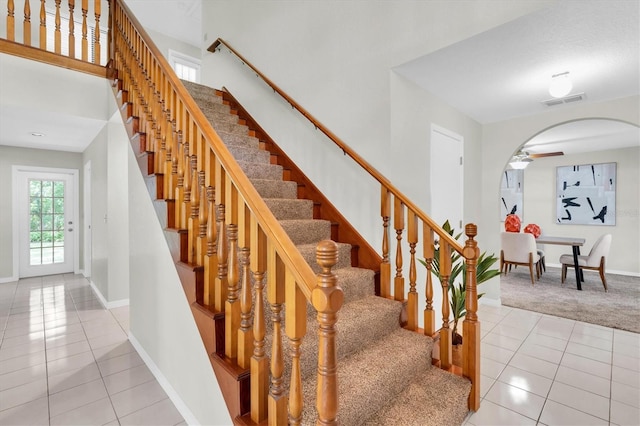 6454 Summerfield Loop, New Port Richey, FL 34655 - stairway with tile patterned flooring, baseboards, a towering ceiling, arched walkways, and carpet floors