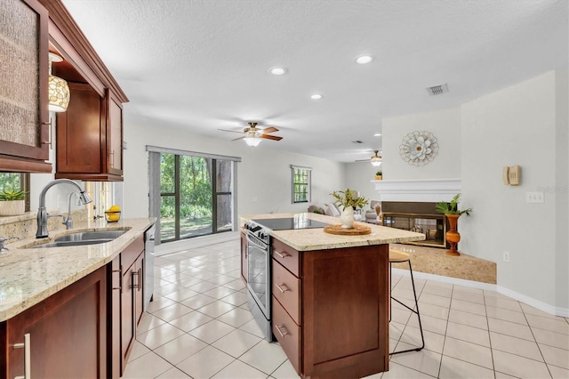 6454 Summerfield Loop, New Port Richey, FL 34655 - kitchen featuring a sink, appliances with stainless steel finishes, ceiling fan, open floor plan, and a glass covered fireplace