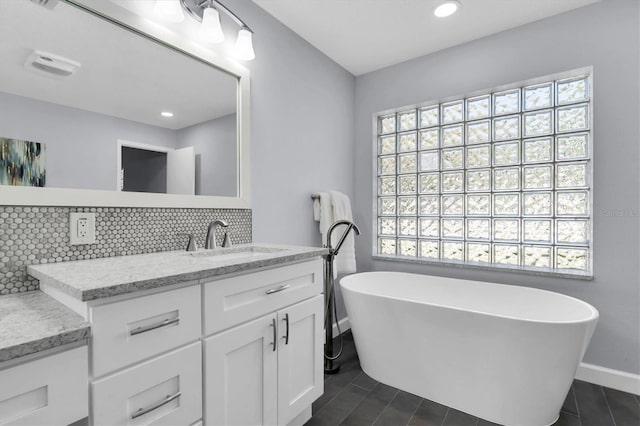 6454 Summerfield Loop, New Port Richey, FL 34655 - full bathroom with decorative backsplash, baseboards, vanity, tile patterned floors, and a soaking tub