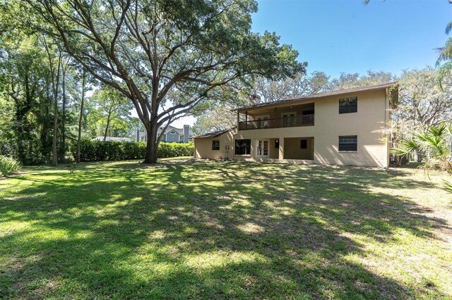 6454 Summerfield Loop, New Port Richey, FL 34655 - back of house featuring a balcony, stucco siding, and a lawn
