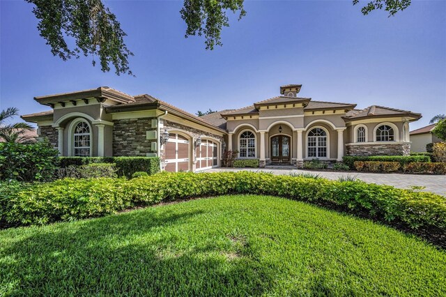 9933 Milano Dr, Trinity, FL 34655 - view of front of home featuring an attached garage, stone siding, and stucco siding
