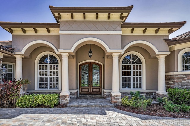 9933 Milano Dr, Trinity, FL 34655 - doorway to property featuring french doors, stucco siding, and stone siding