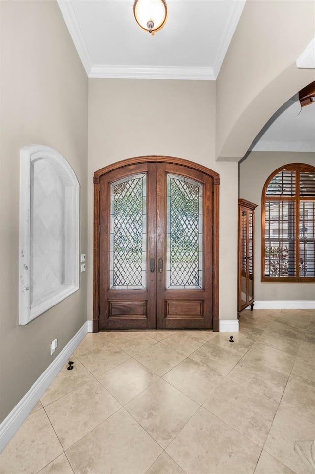 9933 Milano Dr, Trinity, FL 34655 - entryway featuring french doors, ornamental molding, arched walkways, light tile patterned flooring, and baseboards