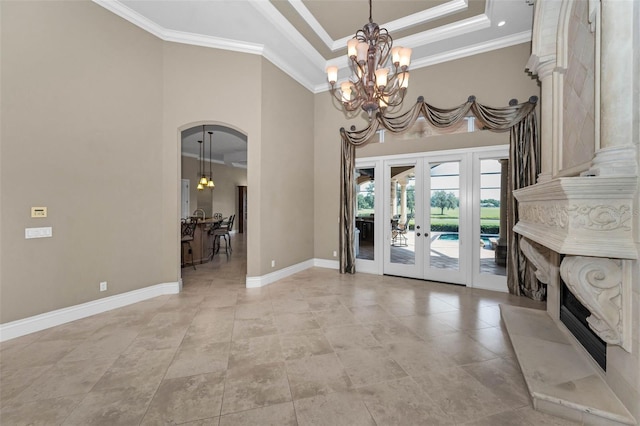 9933 Milano Dr, Trinity, FL 34655 - dining area with a chandelier, ornamental molding, arched walkways, a high ceiling, and french doors