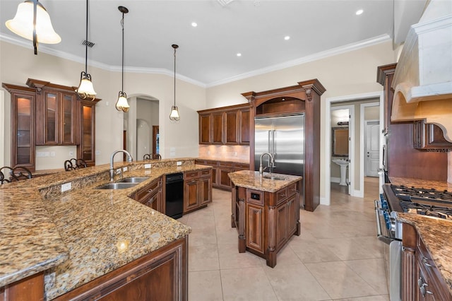 9933 Milano Dr, Trinity, FL 34655 - kitchen with a sink, high quality appliances, arched walkways, a center island with sink, and ornamental molding