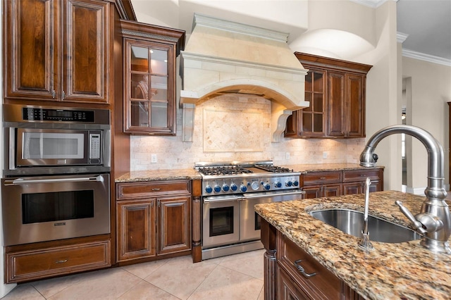 9933 Milano Dr, Trinity, FL 34655 - kitchen featuring appliances with stainless steel finishes, a sink, premium range hood, ornamental molding, and light tile patterned floors