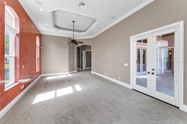 9933 Milano Dr, Trinity, FL 34655 - spare room with french doors, arched walkways, carpet floors, a tray ceiling, and baseboards