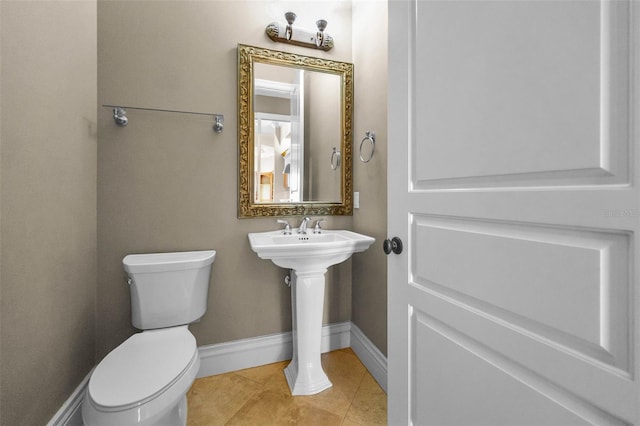 9933 Milano Dr, Trinity, FL 34655 - half bath featuring toilet, tile patterned floors, baseboards, and a sink