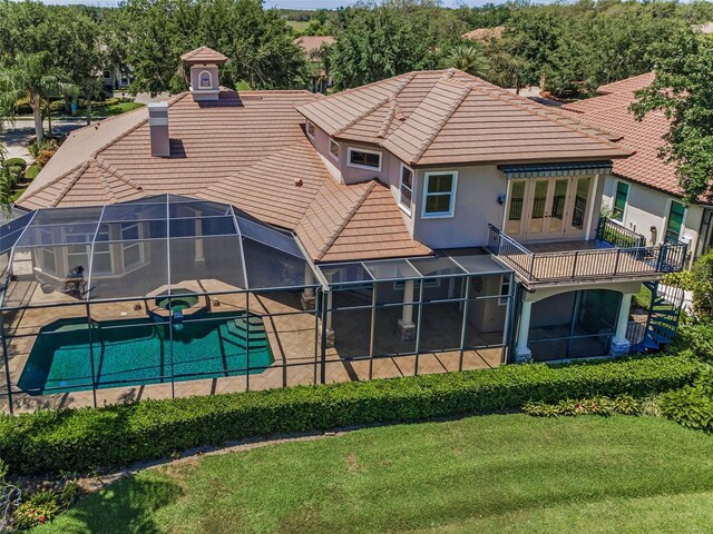 9933 Milano Dr, Trinity, FL 34655 - rear view of house with a pool with connected hot tub, a tile roof, french doors, stucco siding, and a lawn