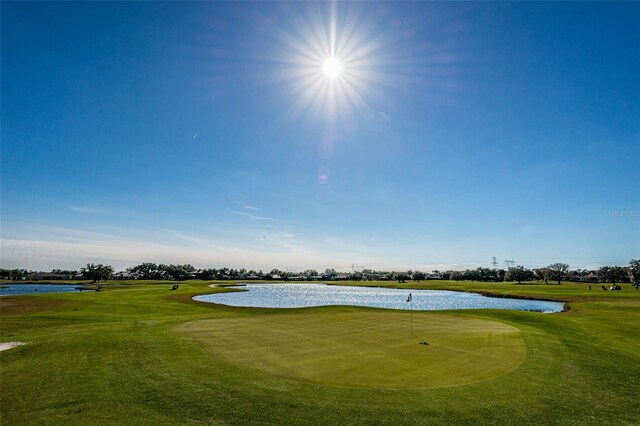 9933 Milano Dr, Trinity, FL 34655 - surrounding community with a water view, view of golf course, and a lawn