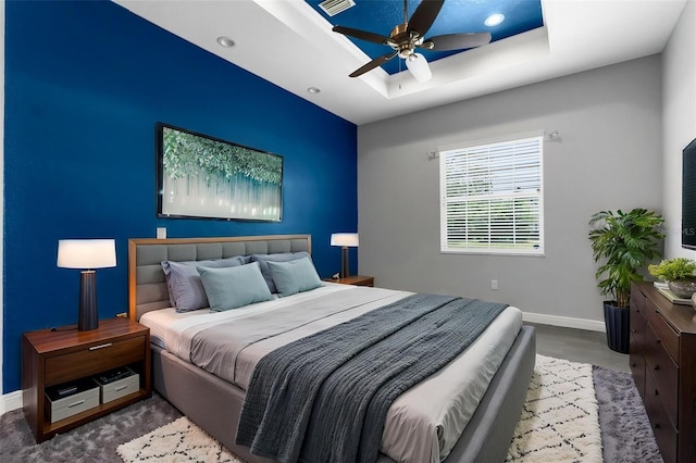 bedroom featuring baseboards, a tray ceiling, recessed lighting, and a ceiling fan