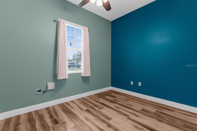 unfurnished room featuring ceiling fan, wood finished floors, and baseboards