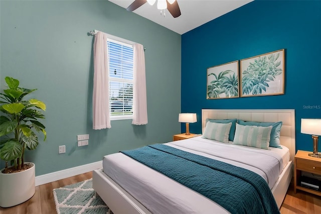 bedroom featuring baseboards, wood finished floors, and ceiling fan