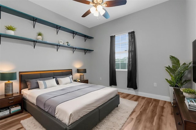 bedroom featuring wood finished floors, baseboards, and a ceiling fan