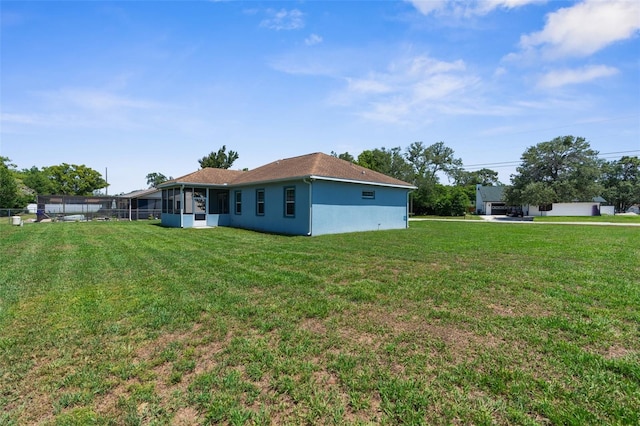 view of grassy yard with a sunroom