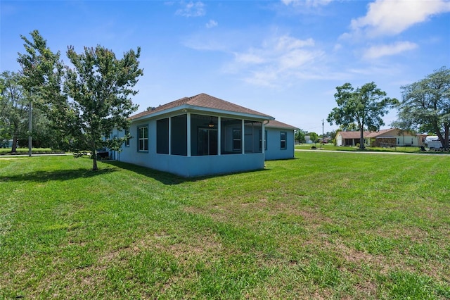 back of property featuring a sunroom and a yard