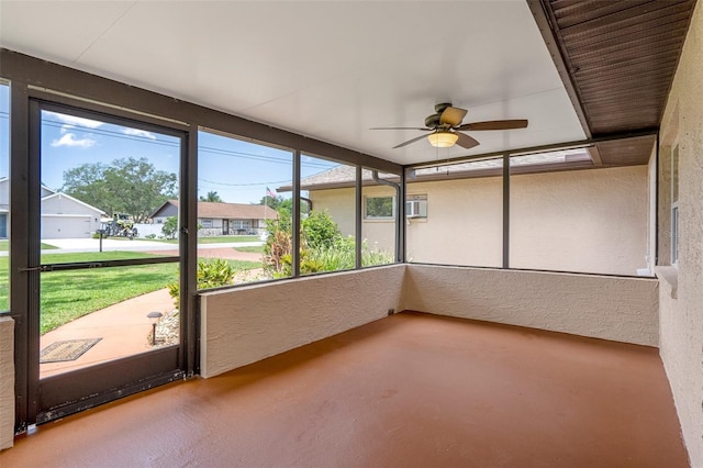 unfurnished sunroom with a ceiling fan and a wall unit AC