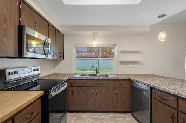 kitchen with stainless steel appliances, a sink, decorative light fixtures, a textured ceiling, and open shelves