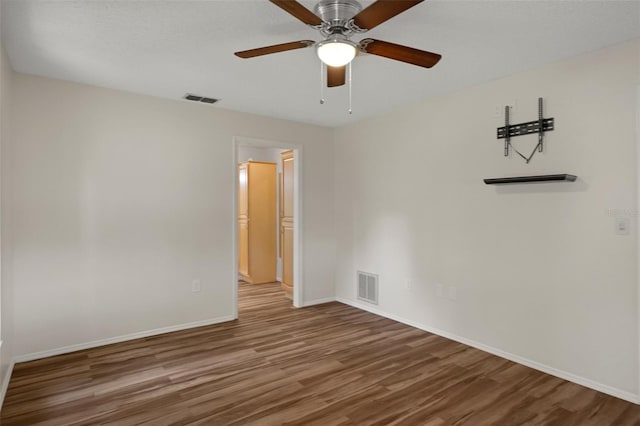 spare room with wood finished floors, baseboards, and a ceiling fan