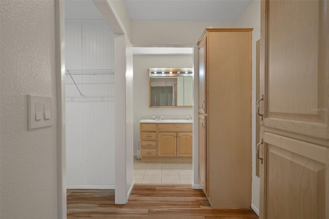 hall with light wood-style flooring and a sink