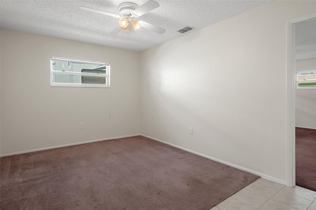 unfurnished room featuring a textured ceiling, ceiling fan, light carpet, and baseboards