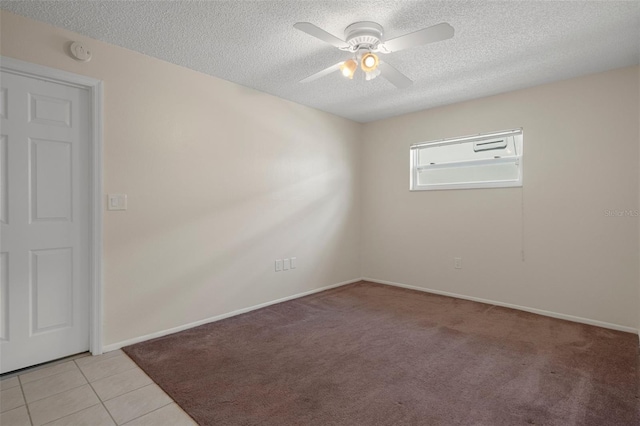 unfurnished room with a textured ceiling, a smoke detector, ceiling fan, baseboards, and light tile patterned floors