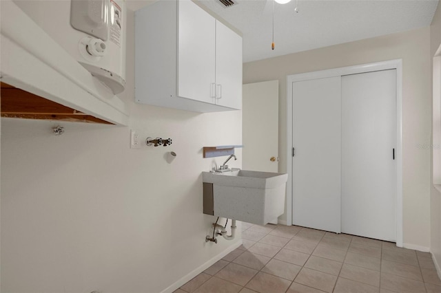 washroom with light tile patterned floors, baseboards, and a sink