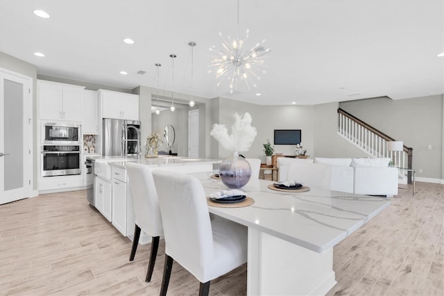 3767 Dragonfly Trl, Odessa, FL 33556 - dining area with light wood finished floors, a chandelier, stairs, recessed lighting, and baseboards